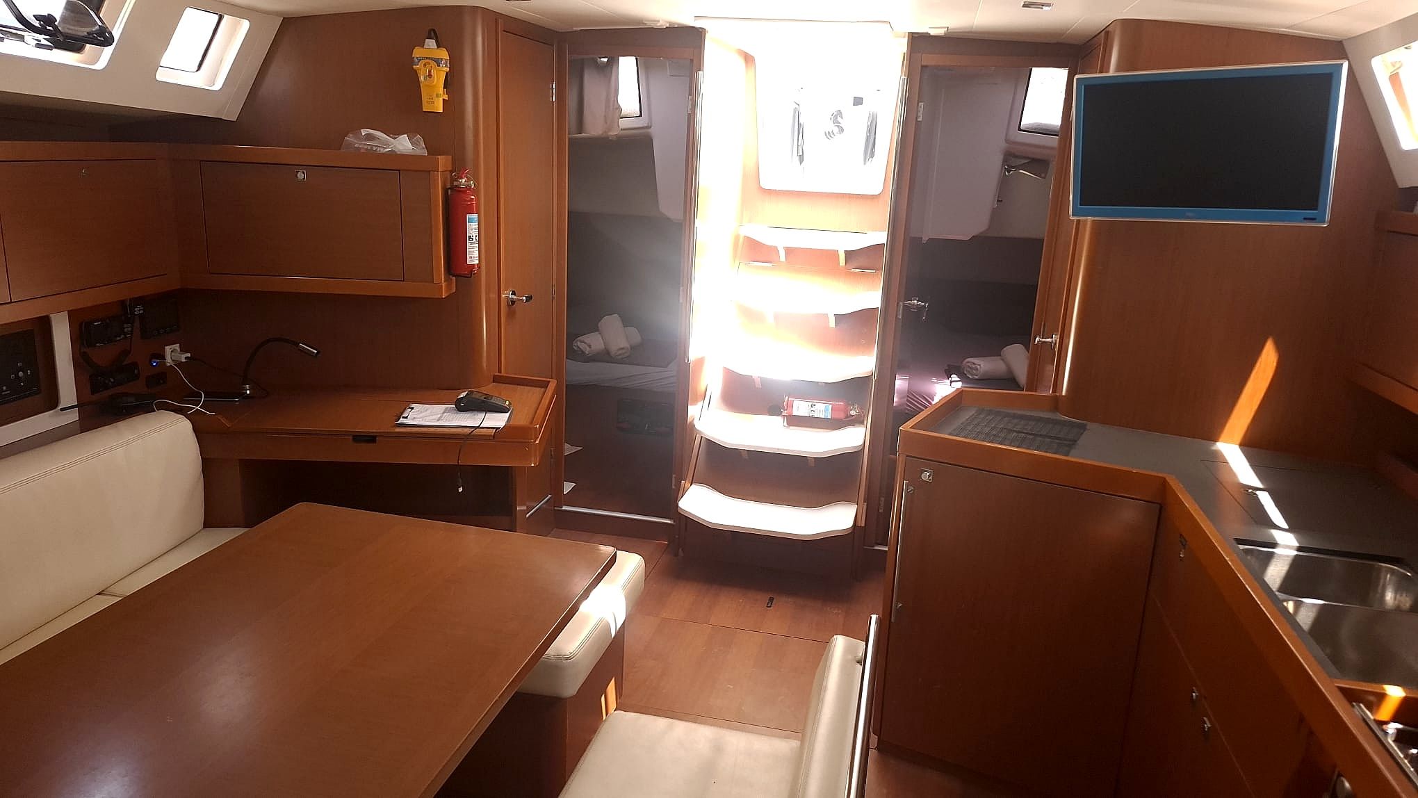 Un espacio interior compacto con kitchenette, zona de estar y ventana pequeña.