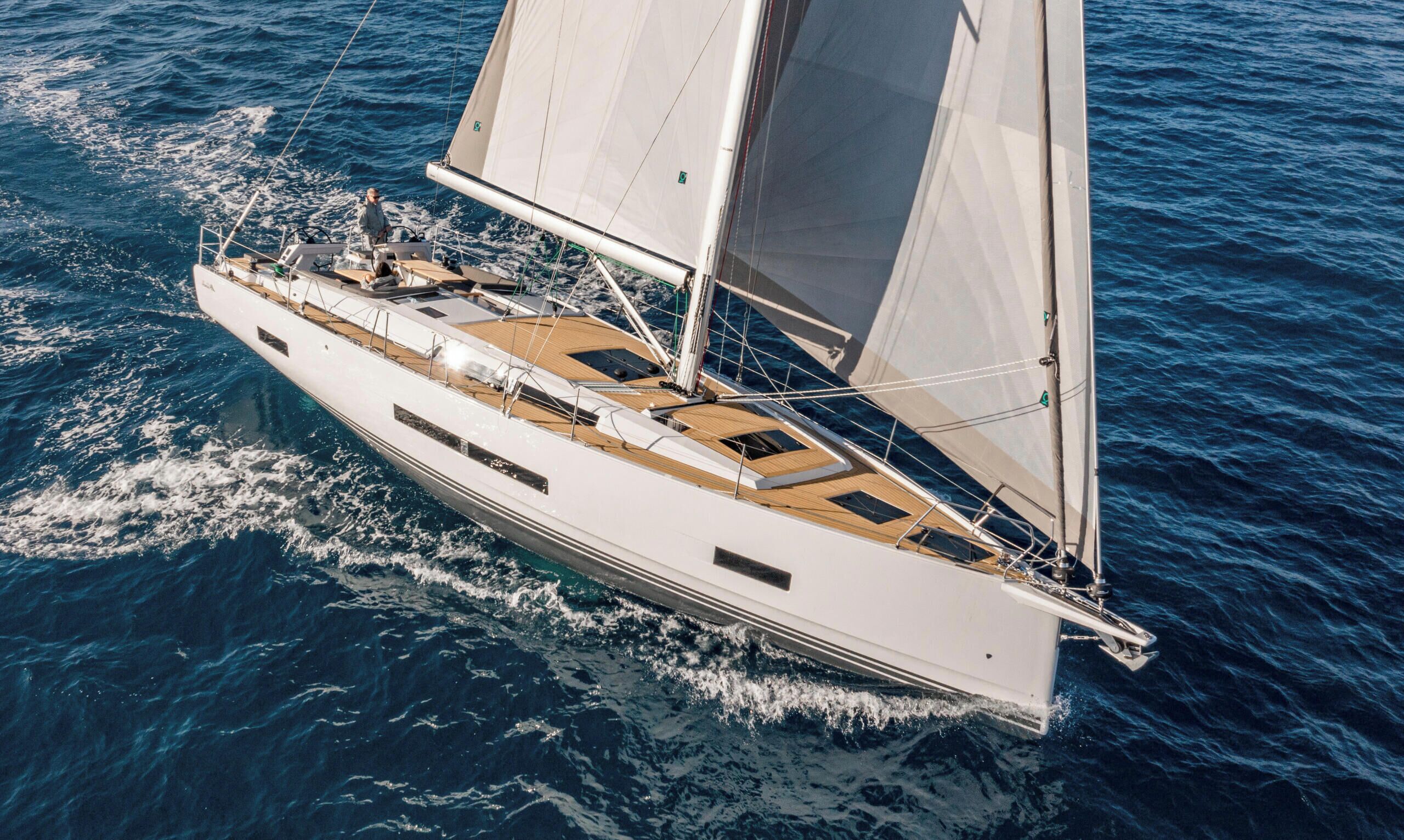 Un grande yacht con più ponti, dotato di vele, che naviga sull'acqua.