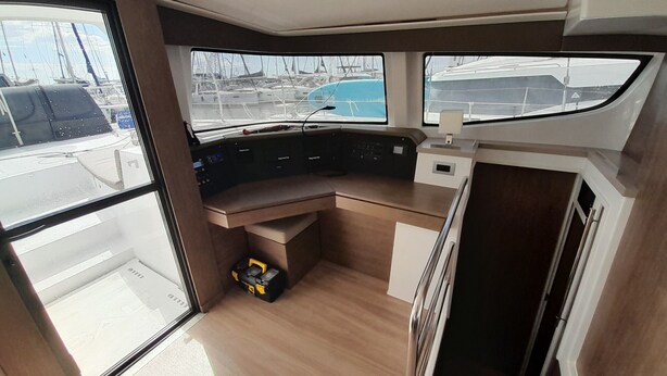 A boat's interior with a control station, windows, and a small storage box. - Sun-Kissed Sailing Adventure in Islas Sarónicas (Alimos)