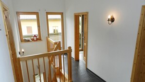 Una escalera de madera que lleva a un balcón con vistas al exterior.