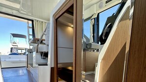 Bootinterieur met een bed, zithoek en uitzicht op het water.