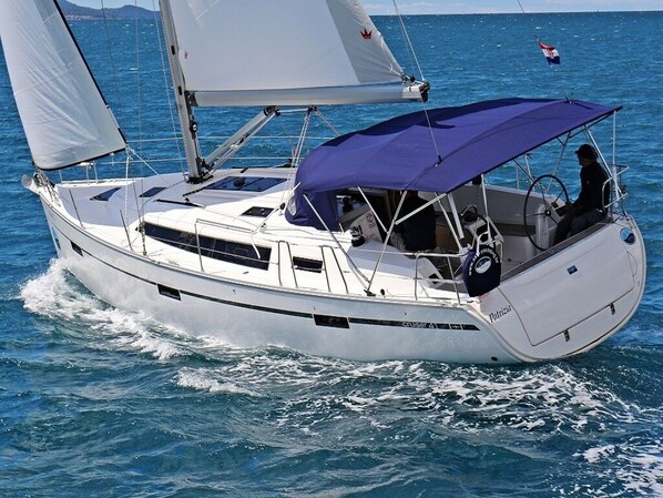 A white sailboat with a blue canopy, a steering wheel, and a person at the helm. - Sun-Kissed Sailing Adventure in Zadar, Croatia (Bibinje)