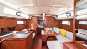 Un interior compacto y bien iluminado con comedor, asientos y una pequeña kitchenette.