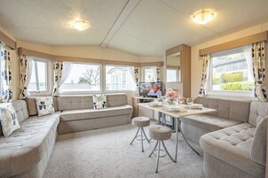 Una sala acogedora con un conjunto de sofás, una mesa de comedor y un televisor.
