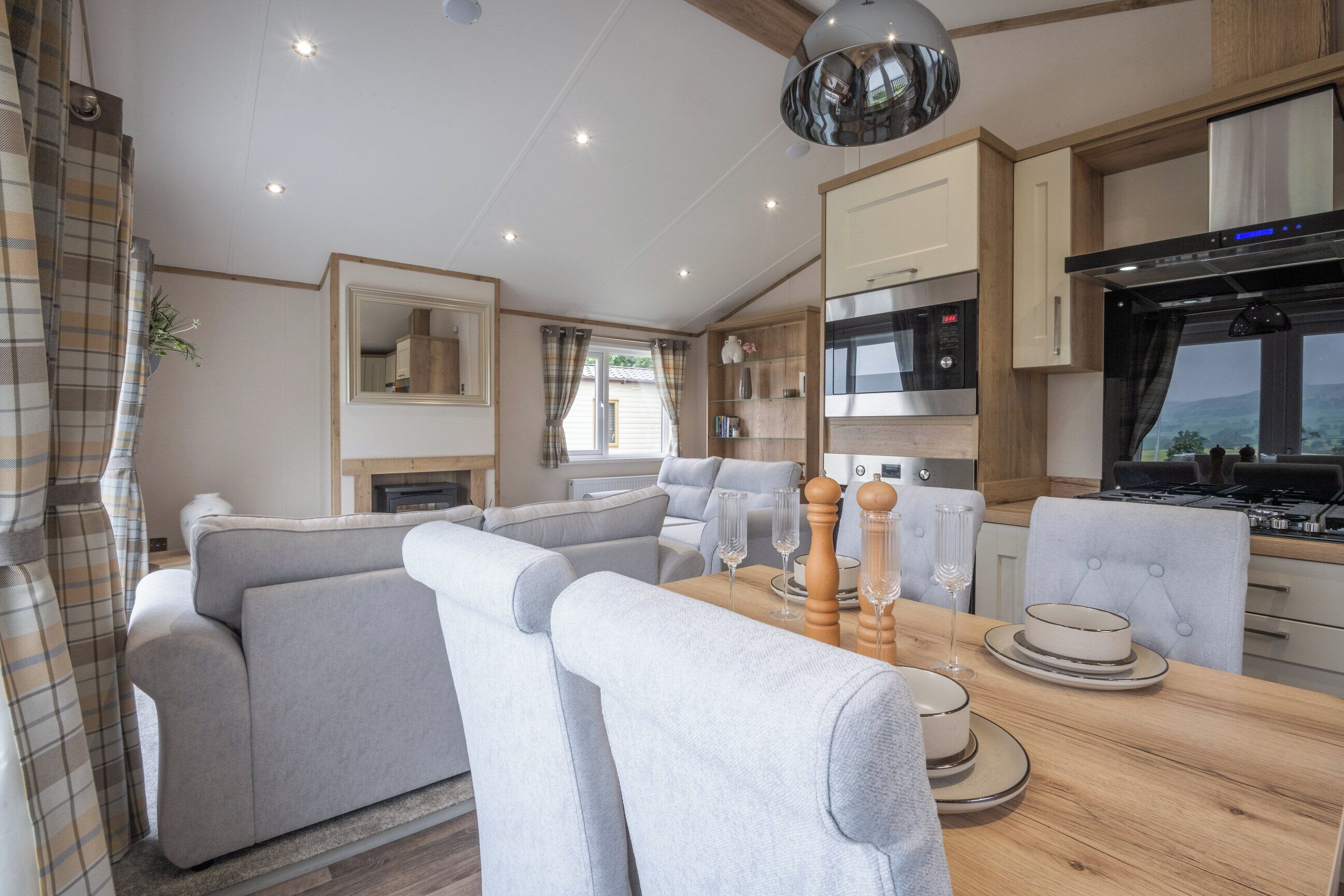 Un intérieur de camping-car moderne comprenant un espace de vie, une table à manger et une cuisine.