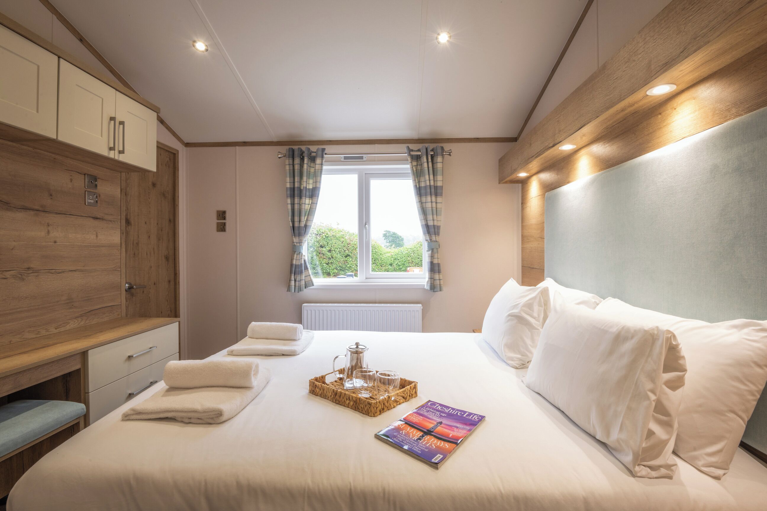 A bedroom with a bed, bedside table, and a window with curtains.