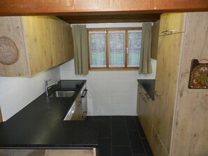 Eine kleine Küche mit Spüle, Herd und Schränken.