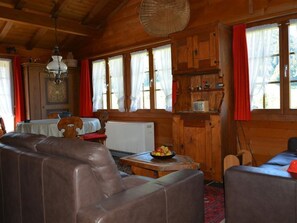 A cozy cabin interior with wooden walls, a dining area, a sofa, and a radio. - Arduus Appartement/Fewo, Dusche oder Bad, WC 4-Bettwohnung by Interhome (Gstaad)