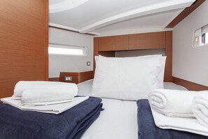 A compact, well-lit cabin with a neatly made bed, a small bedside table, and a window. - Sun-Kissed Sailing Adventure in Split, Croatia (Split)
