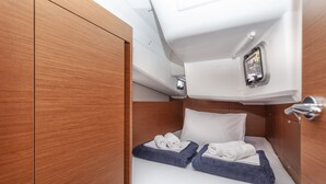 A compact cabin with a bed, a small window, and a control panel. - Sun-Kissed Sailing Adventure in Split, Croatia (Split)