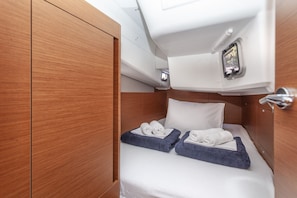 A compact cabin with a bed, a small window, and a control panel. - Sun-Kissed Sailing Adventure in Split, Croatia (Split)