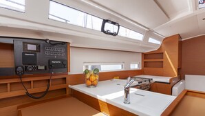 A compact kitchen with a Raymarine navigation system, a sink, a stove, and a fruit bowl. - Sun-Kissed Sailing Adventure in Split, Croatia (Split)