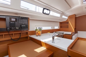 A compact kitchen with a Raymarine navigation system, a sink, a stove, and a fruit bowl. - Sun-Kissed Sailing Adventure in Split, Croatia (Split)