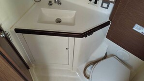 A bathroom with a white sink, a mirror, and a toilet. - Sun-Kissed Sailing Adventure in the Ionian Islands, Lefkada (Lefkada)