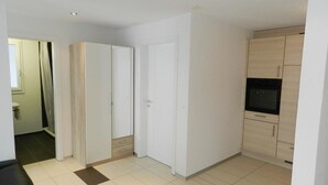 Habitación con armario, puerta y zona de cocina con alacenas.