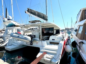 A marina with a white yacht featuring a covered deck, a steering wheel, and a small boat named 'THAI LIFE' docked alongside. - Sun-Kissed Sailing Adventure in Zadar, Croatia (Biograd na moru)