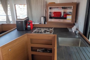 A compact kitchen with a built-in oven, a coffee maker, and a sink. - Sun-Kissed Sailing Adventure in Zadar, Croatia (Biograd na moru)