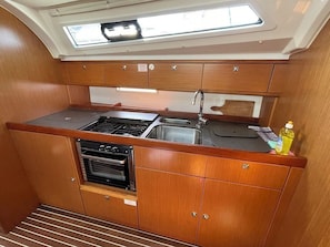 A compact galley with a skylight, a stove, a sink, and wooden cabinetry. - Sun-Kissed Sailing Adventure in Zadar, Croatia (Bibinje)