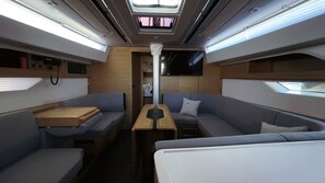 A compact, well-lit interior with a central table, two couches, and a television. - Sibenik Sun-soaked Sailing: A Luxurious Croatian Voyage (Pirovac)
