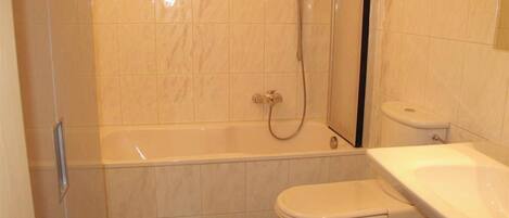 Ein Badezimmer mit Badewanne, Toilette und Dusche.
