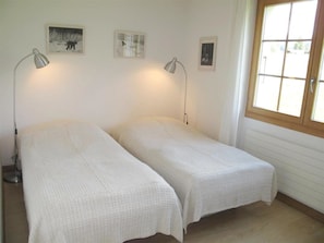 A room with two beds, a window, and wall-mounted lamps. - Grüenbüelti Appartement/Fewo, Dusche oder Bad, WC 6-Bettwohnung by Interhome (Gstaad)
