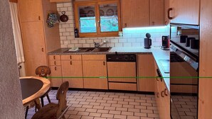 A compact kitchen with wooden cabinets, a window, and a dishwasher.