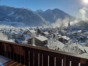 A snow-covered village with traditional buildings and a church, surrounded by mountains. - Bergluft Appartement/Fewo, Dusche oder Bad, WC 6-Bettwohnung by Interhome (Zweisimmen)