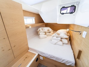 Ein kompaktes Wohnmobil-Interieur mit einem Etagenbett, einem kleinen Fenster und einer Steckdose.