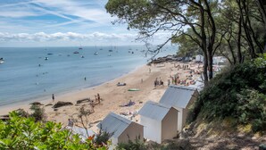 A beach with boats, people, and beach huts. - Guest Room "Le Cocon du Sorcier" in the Marais Breton Vendéen, 25 min from Noirmoutier (Châteauneuf)