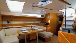 Jachten-Interieur mit Essbereich, gepolsterten Sitzgelegenheiten und einem Schiebedach.