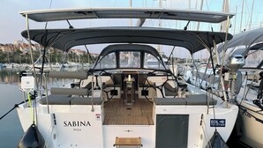 Un yacht nommé « Sabina », doté d’un pont couvert, d’un volant et d’un espace salon.