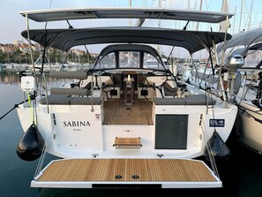 A boat named 'Sabina Pula' with a covered deck, seating area, and a small table.