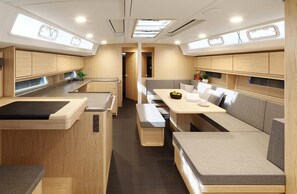 A compact RV interior with a kitchenette, dining area, and seating.