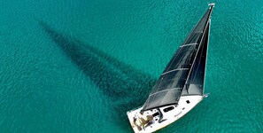 A sailboat with a cabin and deck area, floating on turquoise water. - Sibenik Sun-soaked Sailing: A Luxurious Croatian Voyage (Pirovac)