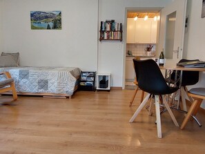 A cozy room with a bed, a desk, and a chair. There's a bookshelf and a small table with a bottle. - Daheim Appartement/Fewo, Dusche oder Bad, WC 3-Bettwohnung by Interhome (Zweisimmen)