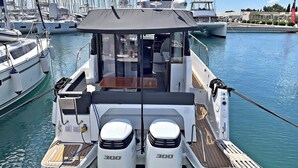 A boat with two 300 horsepower engines, a covered seating area, and a wooden deck. - Sun-Kissed Sailing Adventure in Zadar, Croatia (Bibinje)
