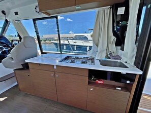 A compact galley with a stove, sink, and storage cabinets. - Sun-Kissed Sailing Adventure in Zadar, Croatia (Bibinje)