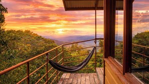 A wooden deck with a hammock, a railing, and a view of the landscape. - El Refugio La Brisa del Diablo – Jungle House (Letrero,)