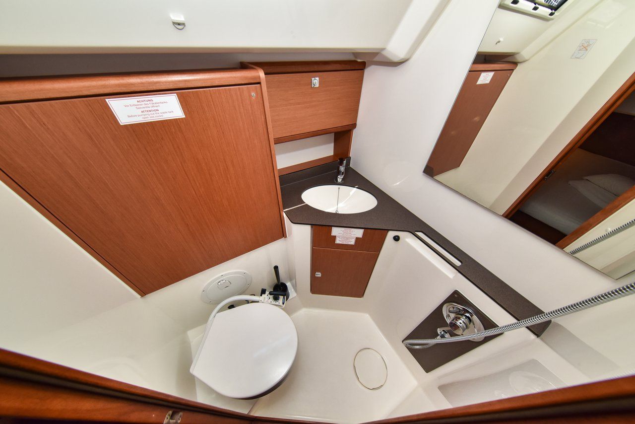 Een kleine badkamer met toilet, wastafel en douche.
