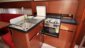 Una cocina compacta con lavamanos, estufa y armarios de madera.