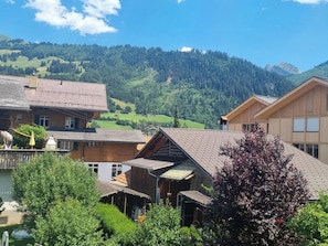 A traditional chalet-style building with a sloped roof, surrounded by lush greenery and a mountainous backdrop. - Bachhüsi Appartement/Fewo, Dusche oder Bad, WC 6-Bettwohnung by Interhome (Zweisimmen)