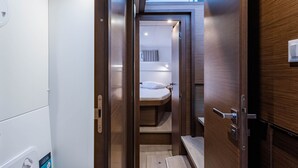 Un baño moderno y estrecho con tragaluz, un inodoro y un banco.