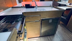 A modern kitchen with a central island, stainless steel appliances, and skylights. - Sun-Kissed Sailing Adventure in Northern Croatia (Novi Vinodolski)