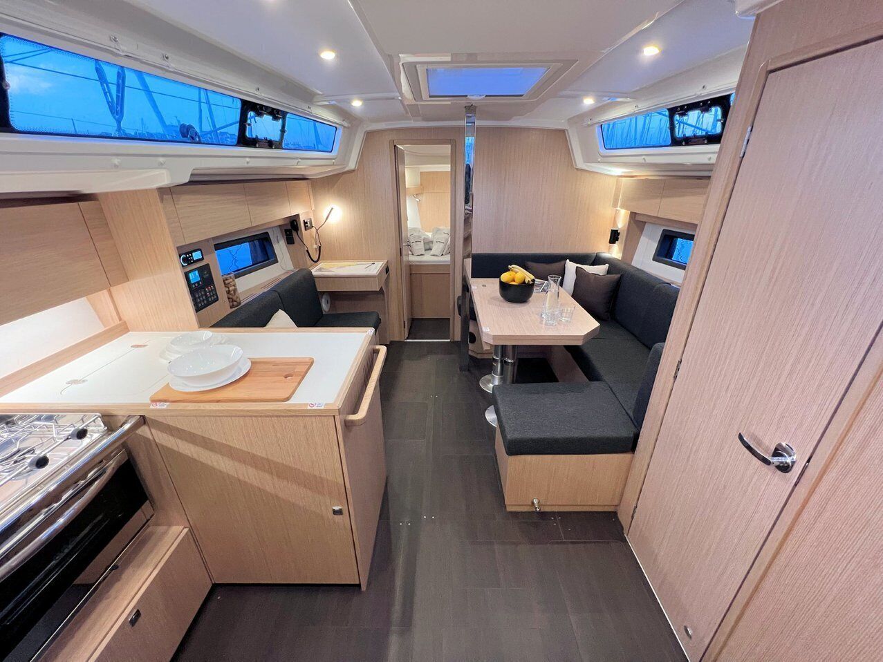 A compact RV interior with a kitchenette, dining area, and a small sleeping space.