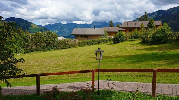 A rural setting with a wooden fence, a paved path, and a lamp post. - Zapfe (Küenzi) Appartement/Fewo, Dusche oder Bad, WC 6-Bettwohnung by Interhome (Gstaad)