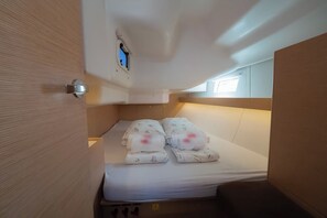 Um pequeno alojamento com uma cama, uma janela e uma porta.