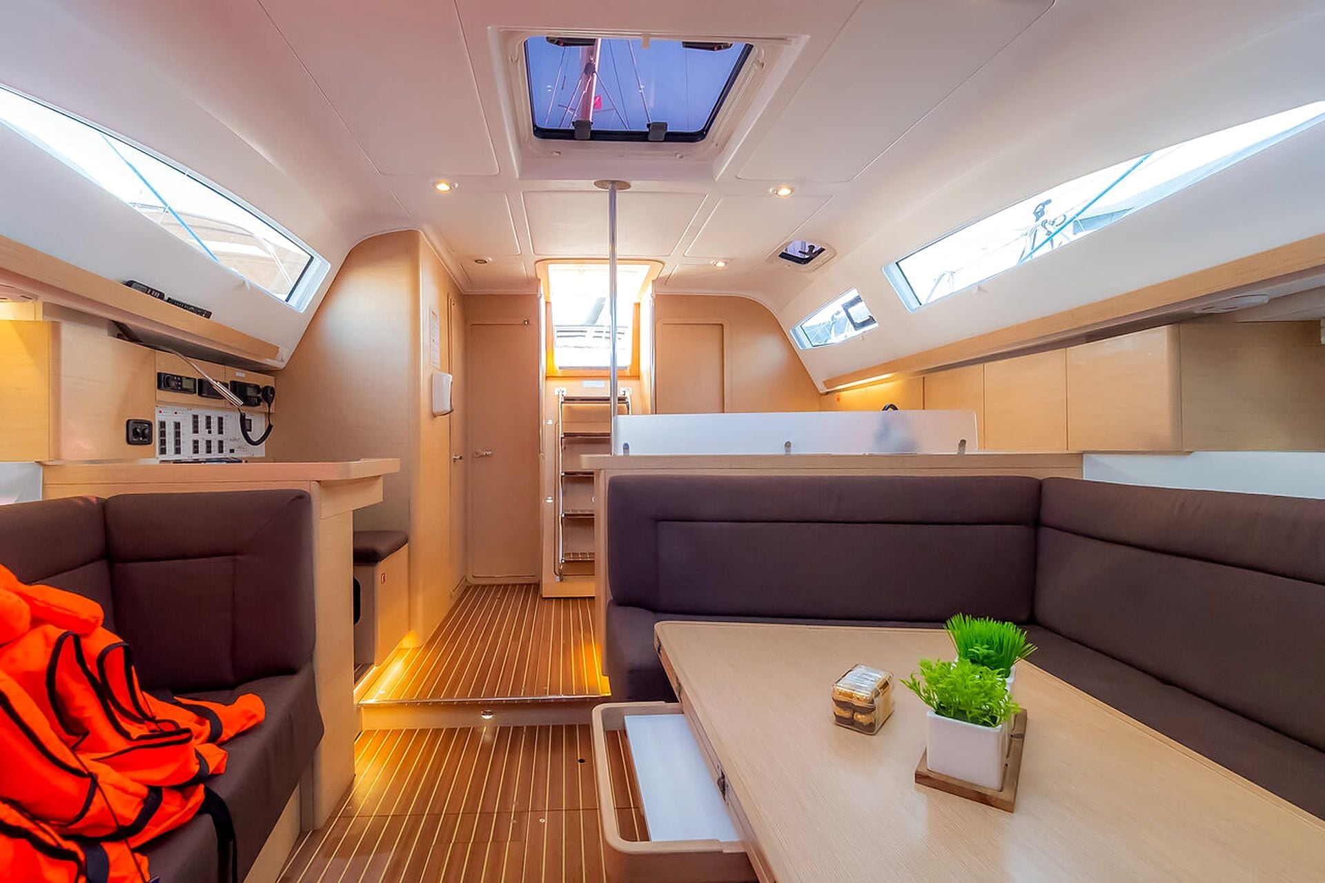 A compact interior with a kitchenette, seating area, and a small table with a plant.
