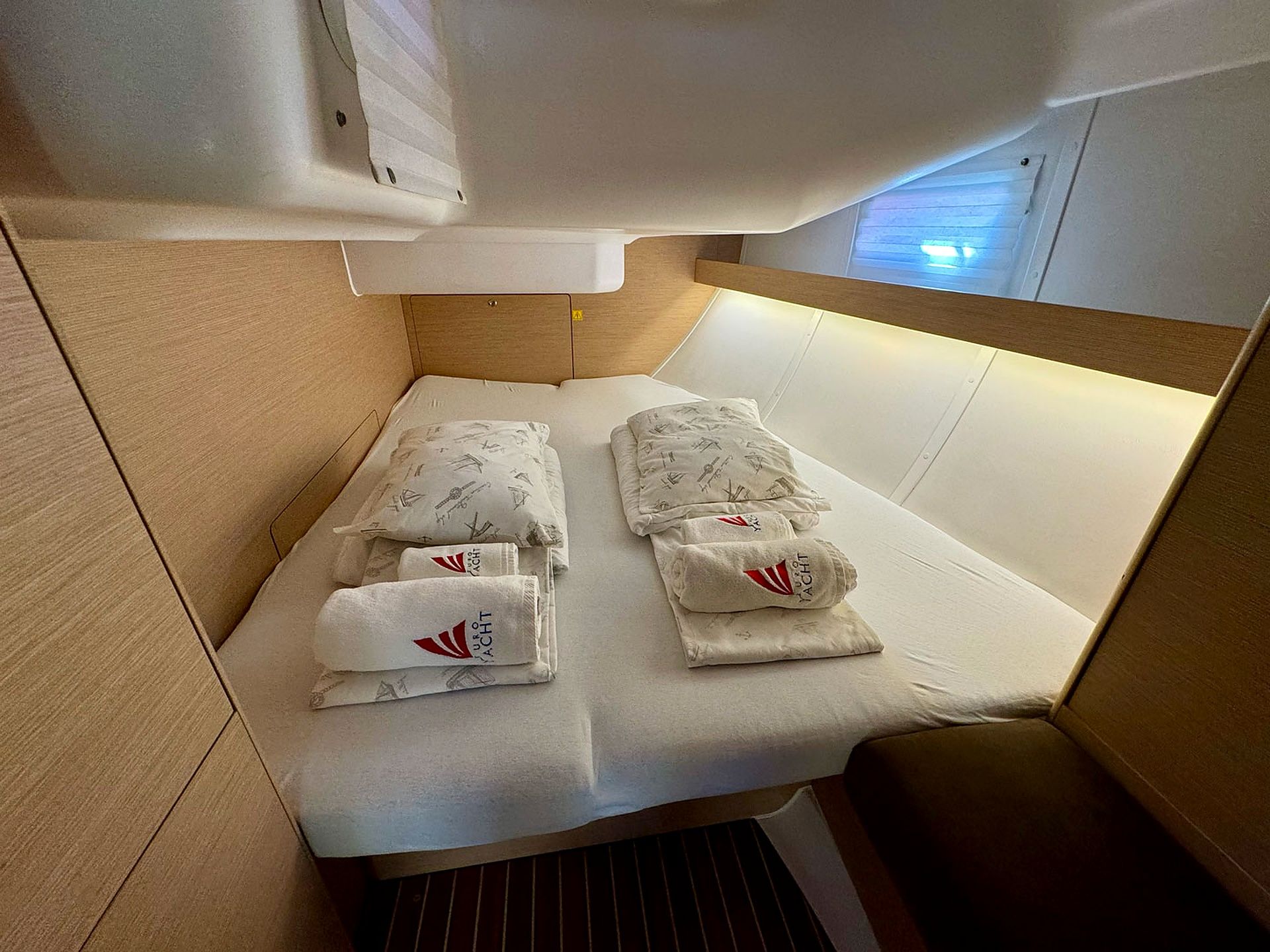 A compact cabin with a bed, pillows, and towels.