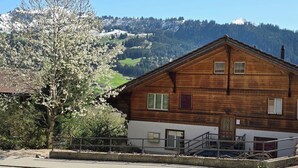 A wooden house with a balcony, a staircase, and a view of a mountain. - Am Ryschbächli Appartement/Fewo, Dusche oder Bad, WC 6-Bettwohnung by Interhome (Zweisimmen)