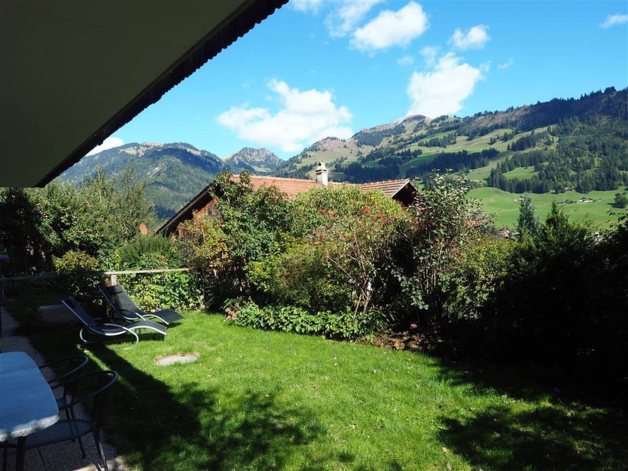 Blick auf eine Berglandschaft mit Haus und Garten.